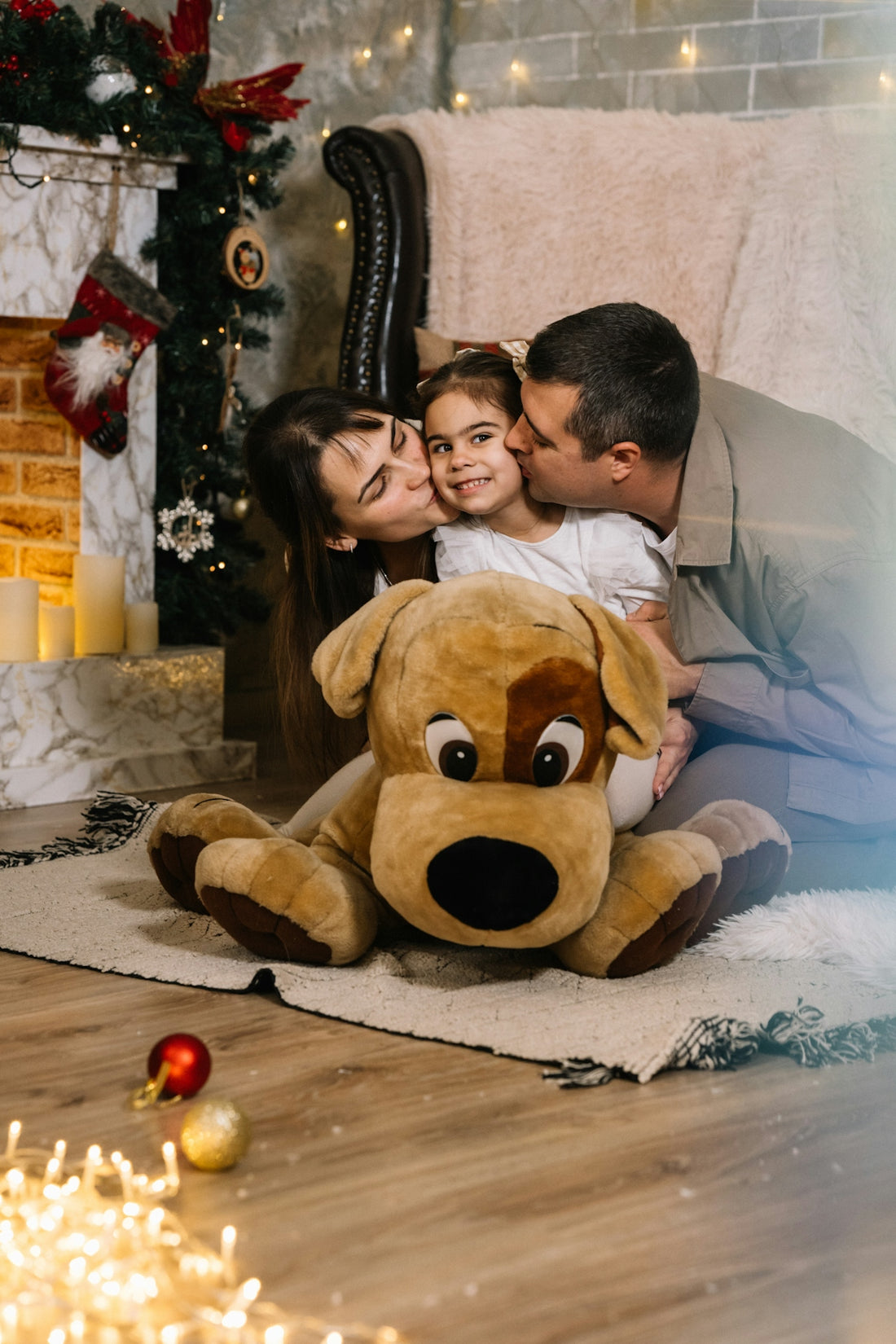 A man and a woman sitting on a floor with a large stuffed dog