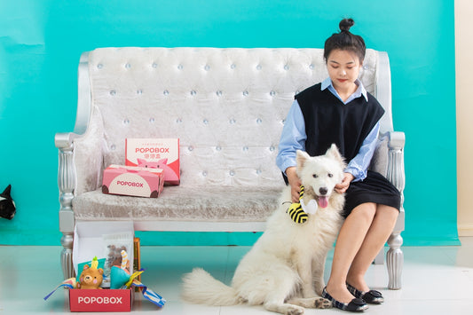 A woman sits with a dog, posing.