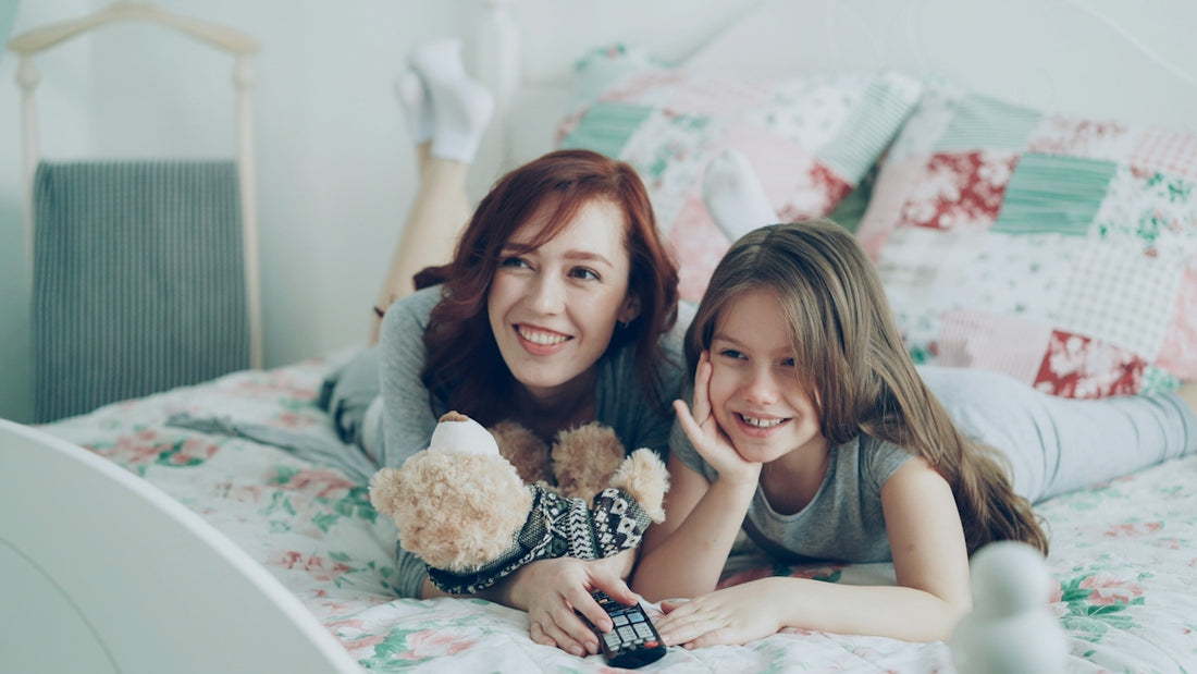 Mother and daughter smile while watching television