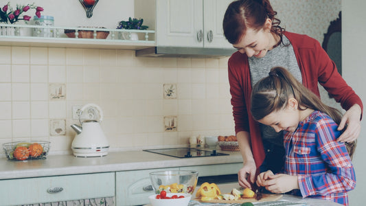 A mother and daughter cook together in the kitchen
