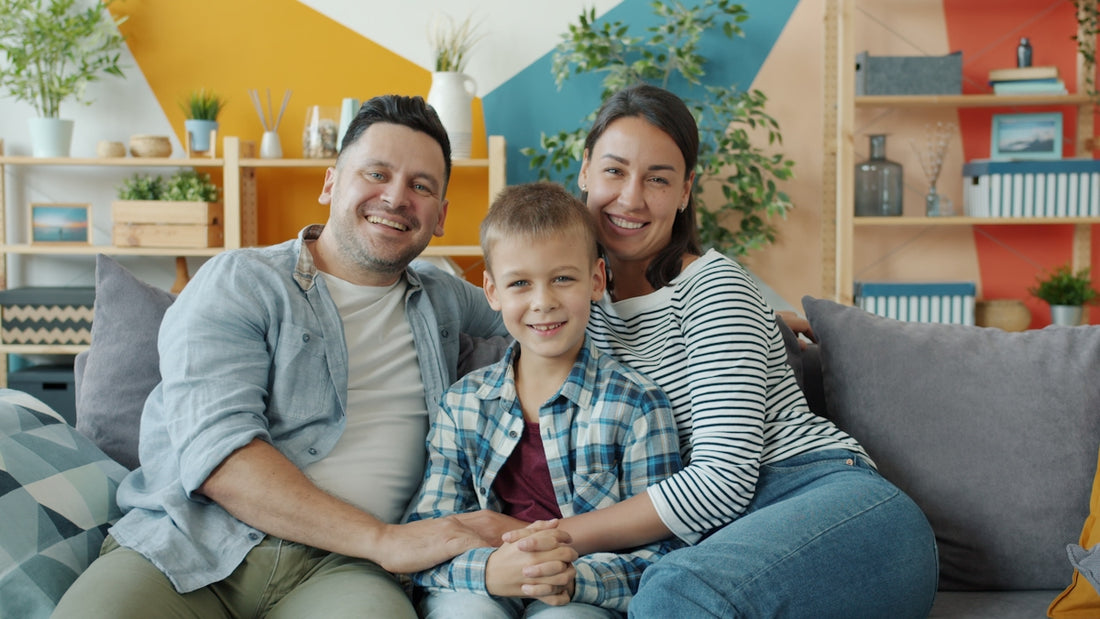 A happy family of three sitting on a couch