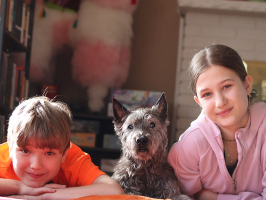 Two children and a dog relaxing indoors.