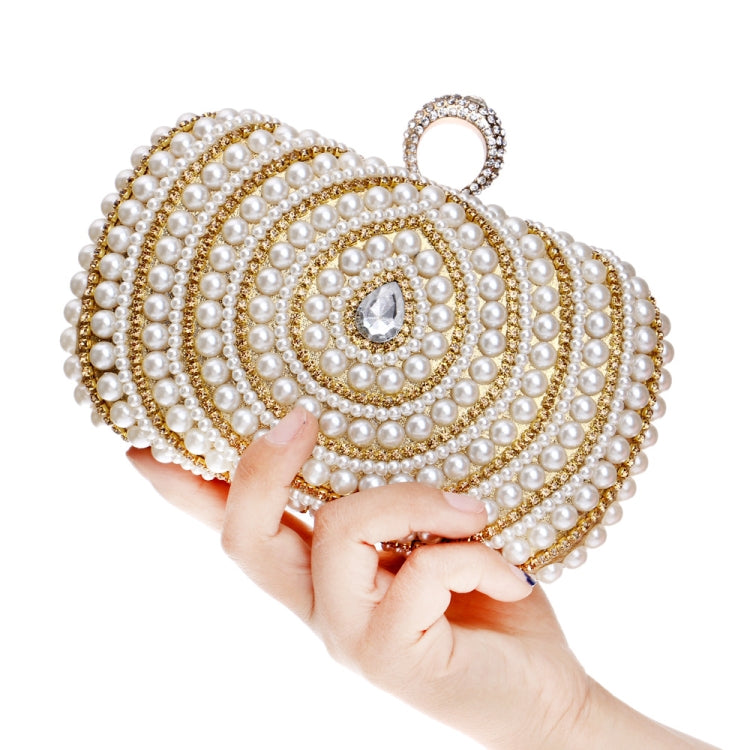Ivory pearl clutch with gold-tone detailing, held in one hand