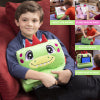 A young boy sits on a red couch, hugging a Unicorn Plush Pillow Tablet Stand—an iPad & phone holder. Smaller images show a child propping up a tablet, carrying the stand by its handle, and storing items inside.