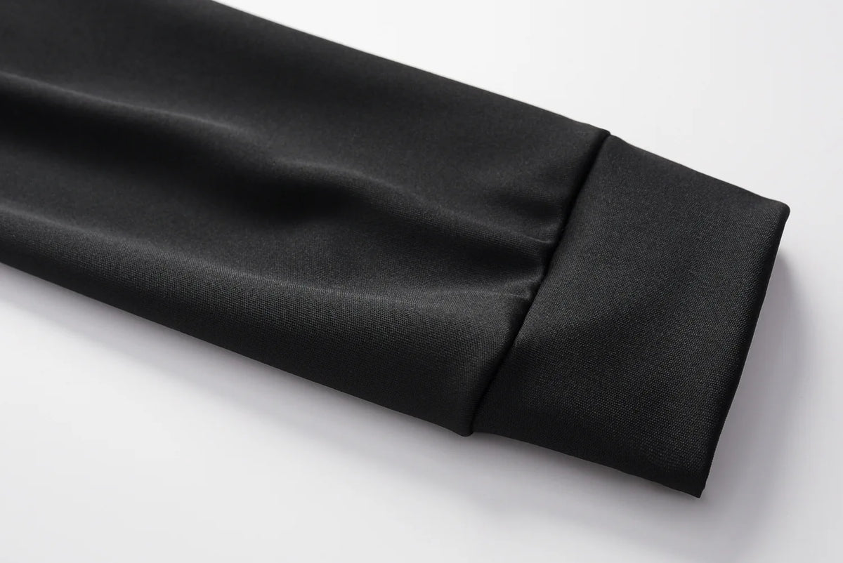 Black two-piece set sleeve cuff detail with smooth fabric fold