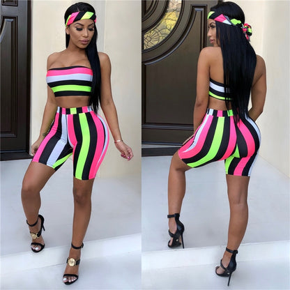 A woman models the Women's Striped Two-Piece Summer Set—featuring a strapless crop top, high-waisted shorts in neon stripes, a matching headscarf, and black heels—posing to show both front and back views.