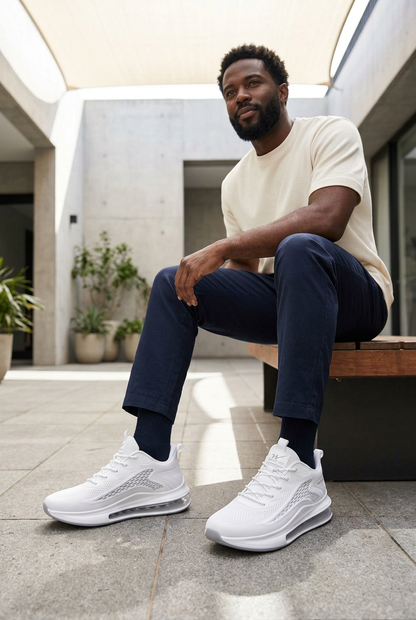 Black male model wearing white knit trainers with visible heel air-window soles