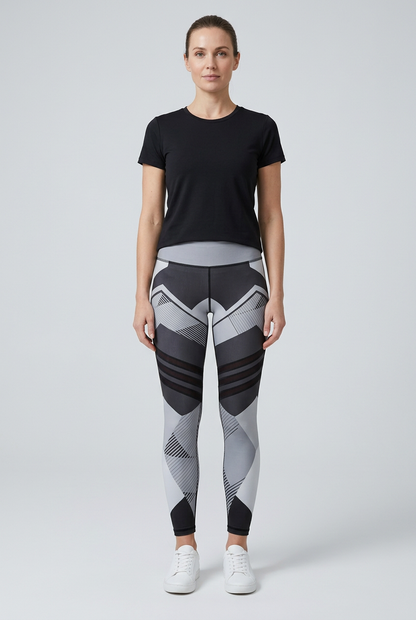 Model wearing black, white and grey geometric-print yoga leggings with a black styling top and white trainers